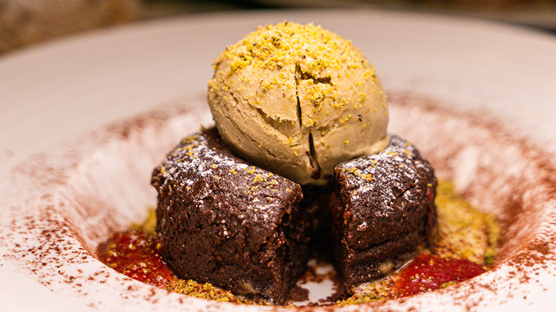 Warm chocolate cake and pistachio ice cream with berries